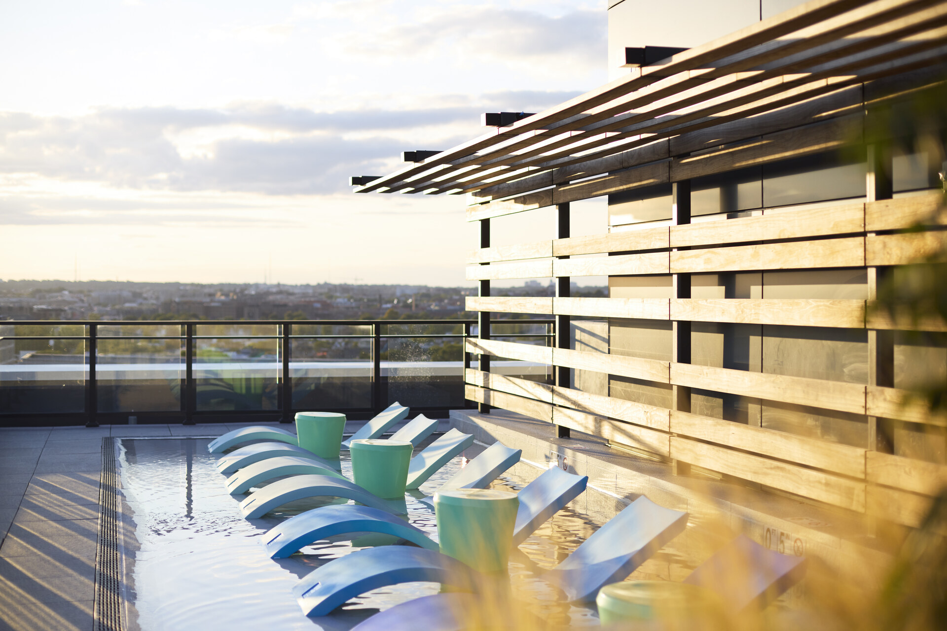 Poolside area at The 202 in DC, featuring lounge chairs with a beautiful sunset backdrop, creating a relaxing outdoor environment.