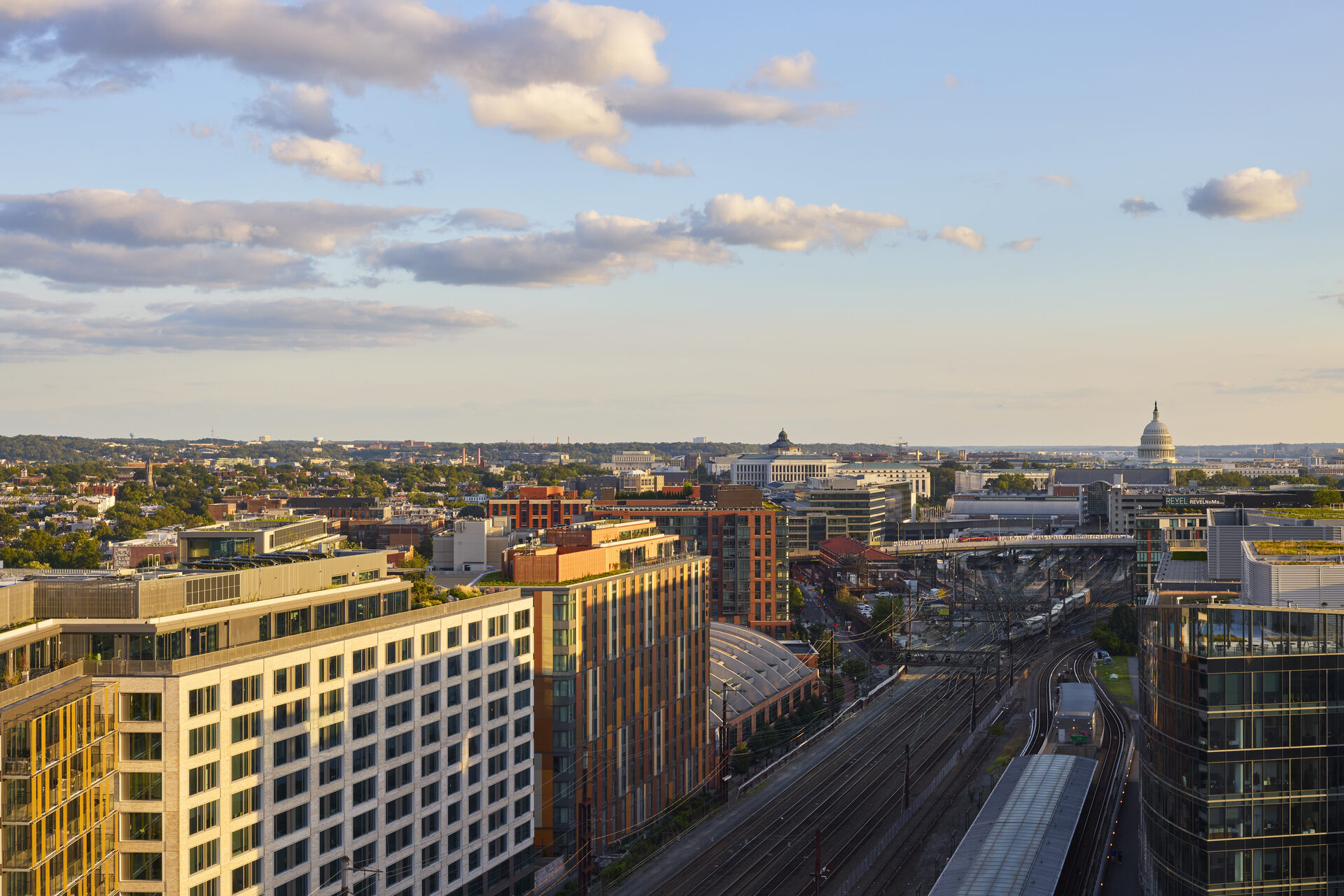 Aerial view of The 202 building in DC at dusk, showcasing its illuminated facade and the surrounding urban environment.