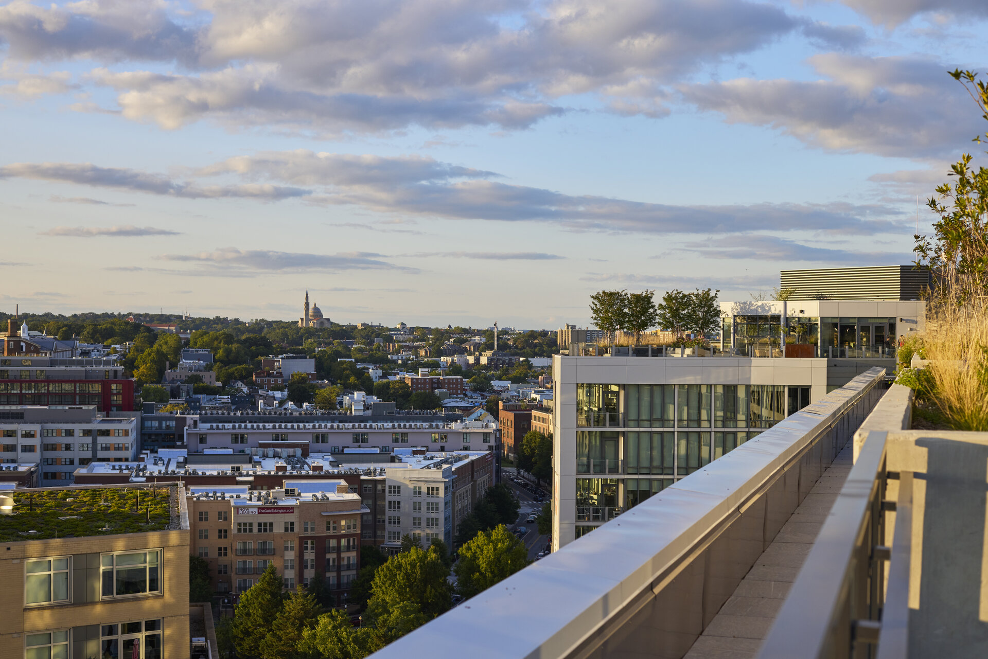 Aerial view of The 202 building in DC at dusk, highlighting its illuminated exterior against the evening sky.