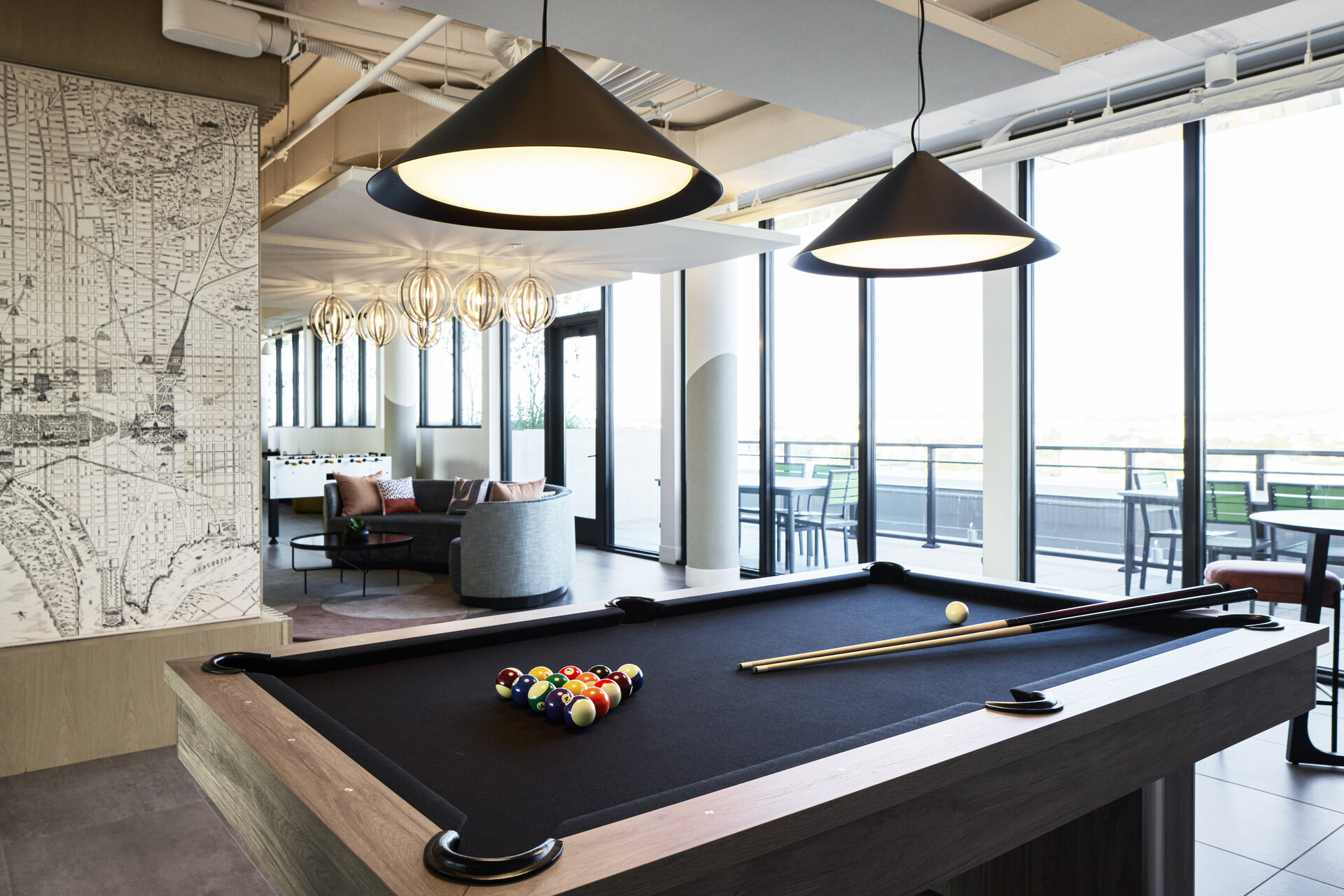 Game room at The 202 in DC featuring a pool table surrounded by modern decor and seating.